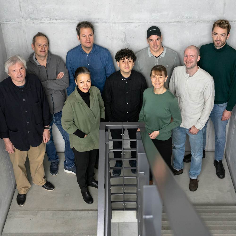 The Studio 7.5 design team standing together in a group in a stairwell.