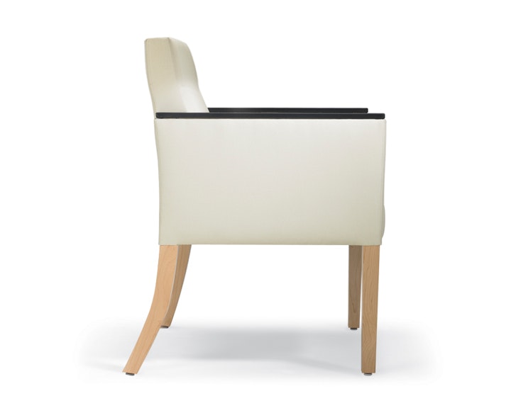 A side view of a Brava 862 Chair in white textile with urethane arm caps and maple legs.