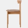 Profile view of an oak Comma Chair.