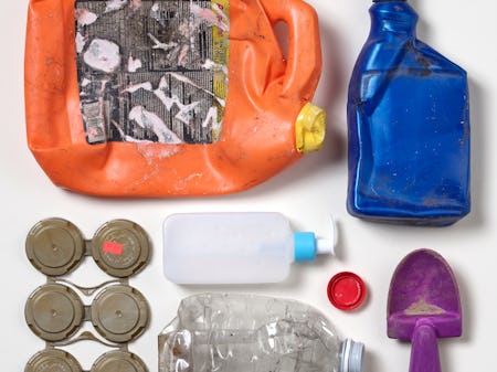 Seven  pieces of colorful, ocean-bound plastic trash laid out in a square pattern on a white backdrop.