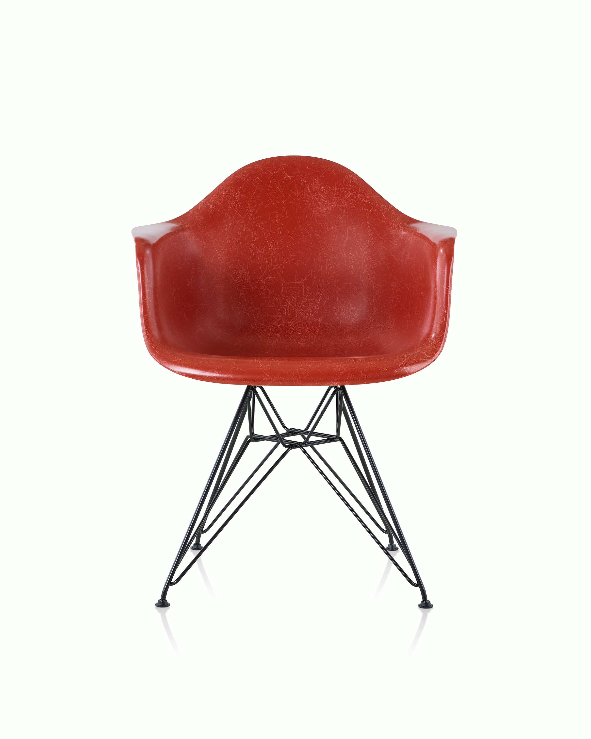 A red Eames Molded Fiberglass Chair with arms and a wire base, viewed from the front.