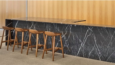 Four brown counter-height stools at a dark grey and white counter