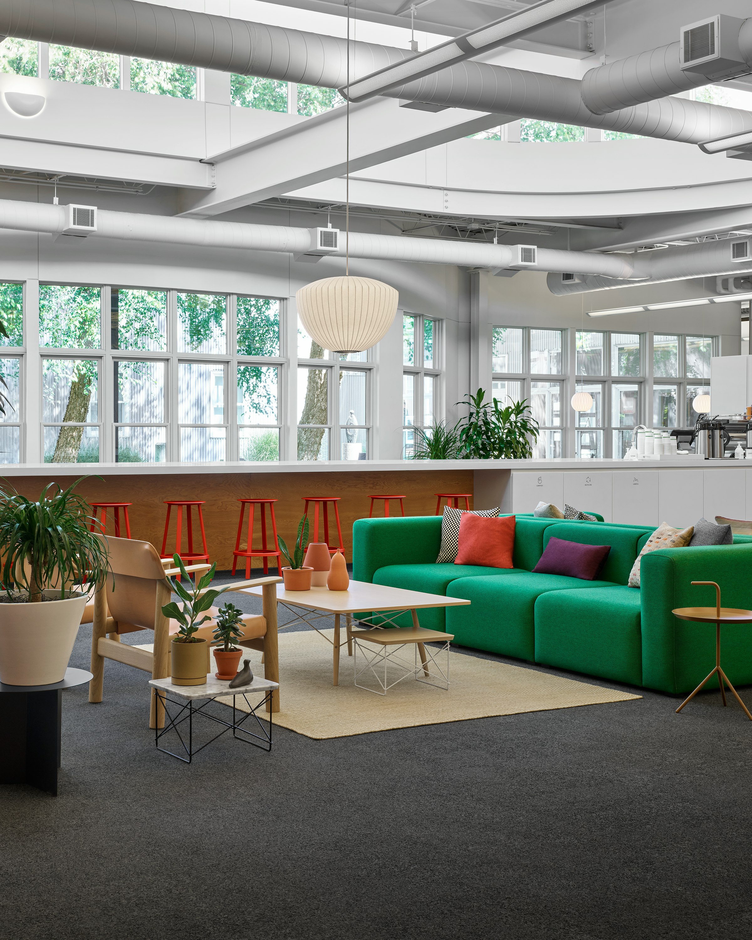 A green Mags Soft Sofa across from a Bernard Chair and Eames Coffee Table in a collaborative front door space.