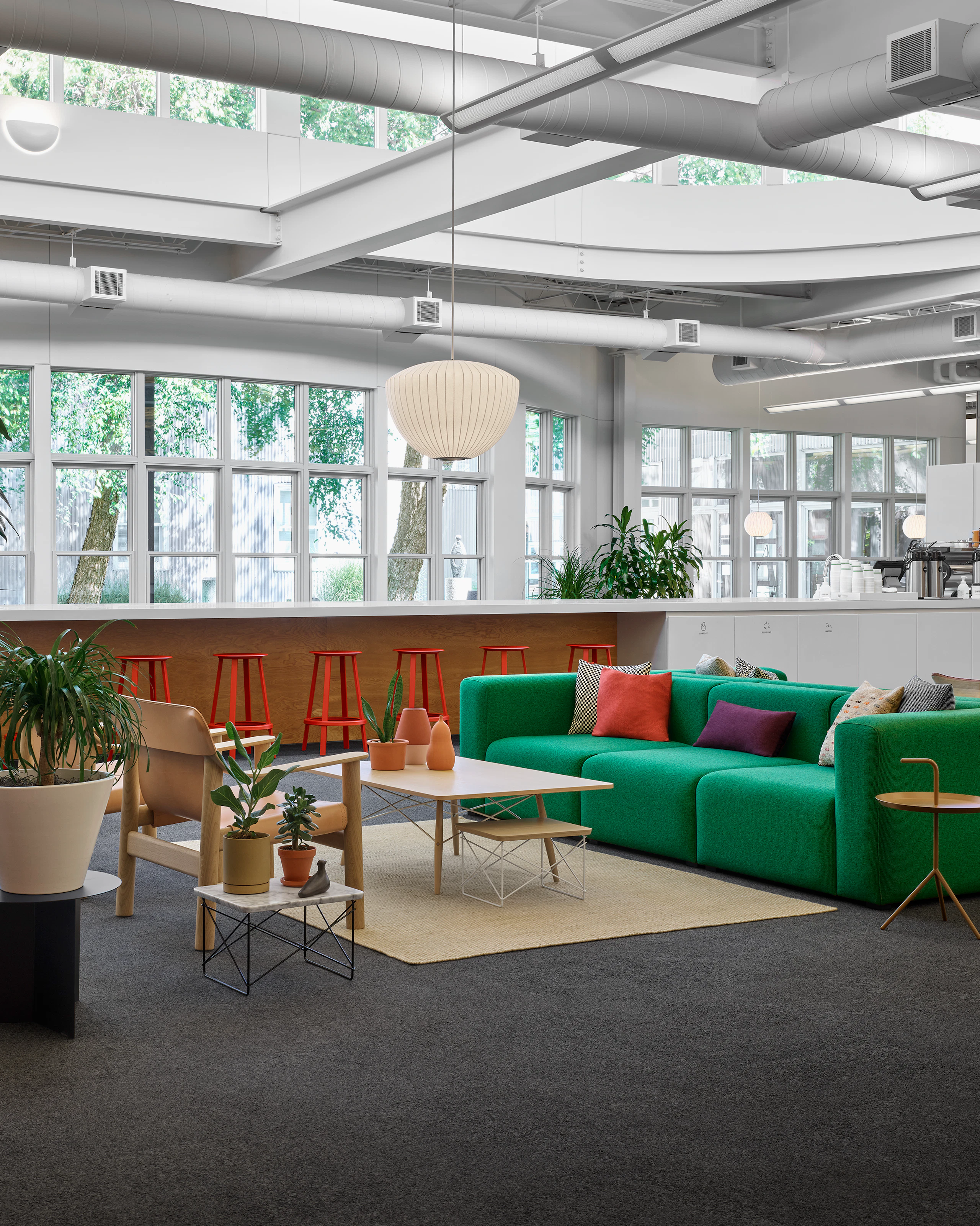 A green Mags Soft Sofa across from a Bernard Chair and Eames Coffee Table in a collaborative front door space.