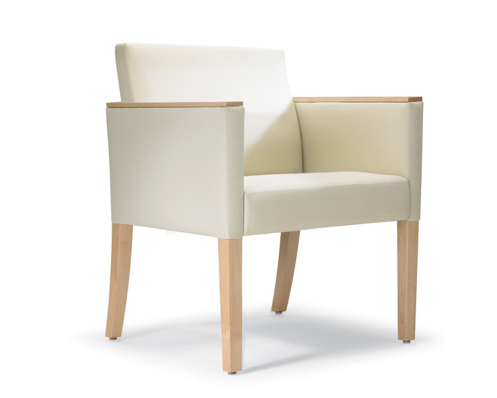 A three-quarter view of a Brava 862 Chair with maple frame, maple arm caps, and white textile.