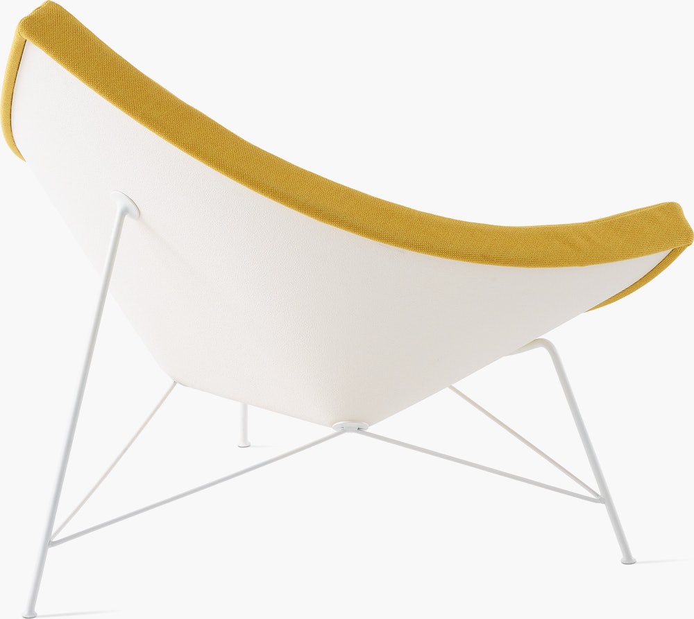 Three-quarter rear view of a  Nelson Coconut Lounge Chair with yellow Mode  fabric, focusing on the white shell.