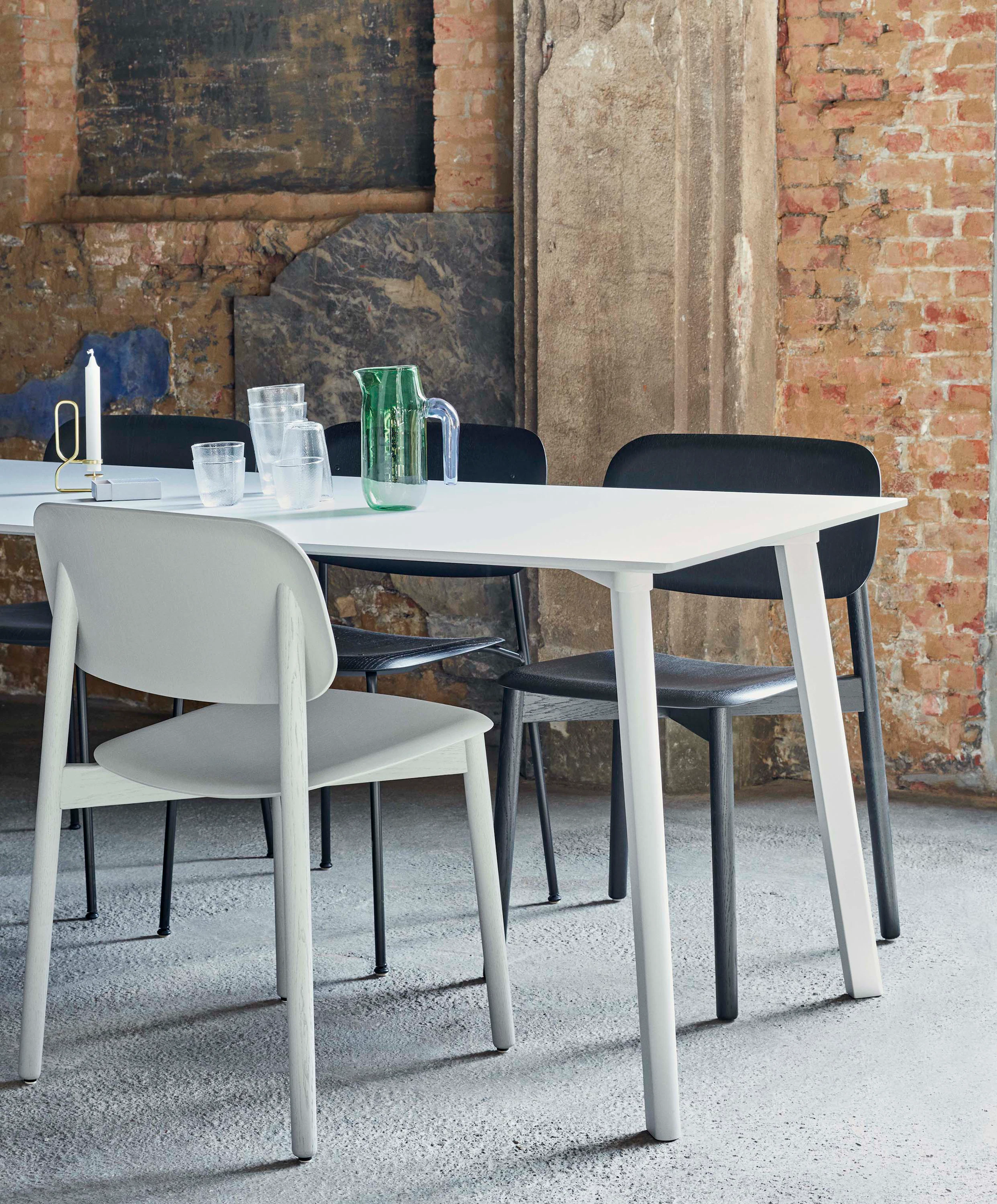 White and black Soft Edge Chairs around a Copenhague Deux table.