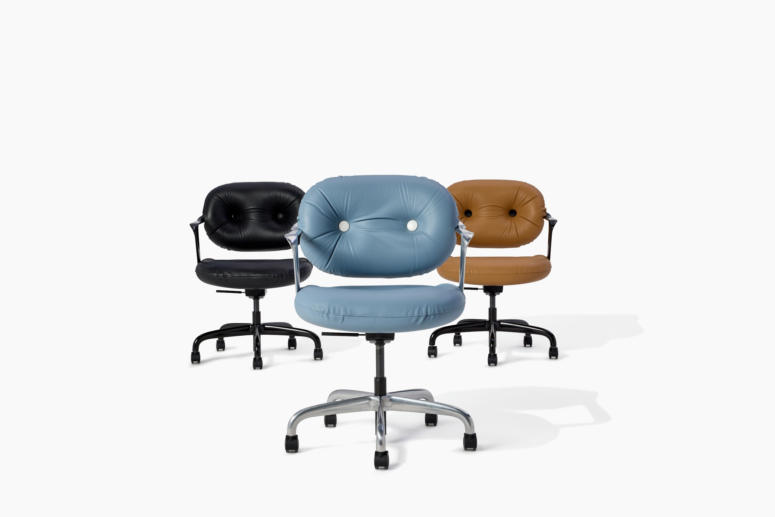 Three Morrison Hannah chairs with arms facing foward. One in black leather, one in light brown leather and the other in light blue leather.