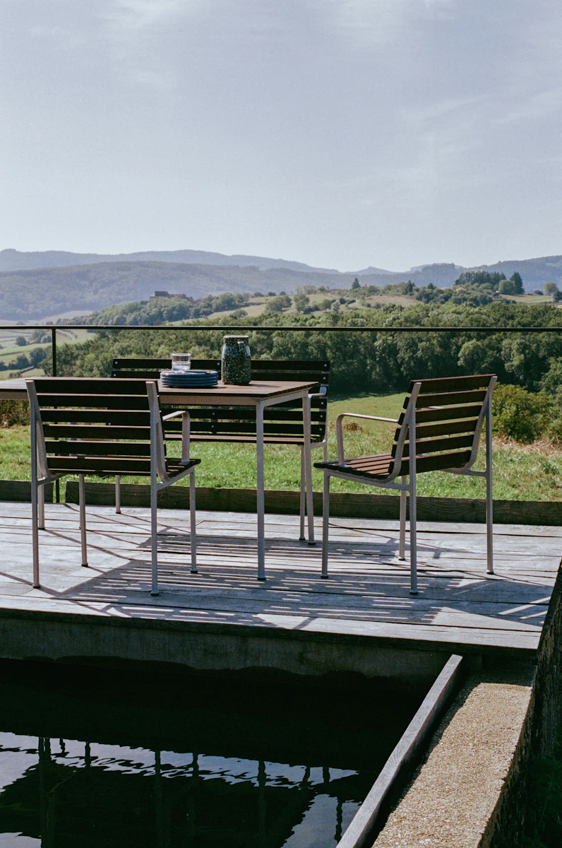 Modern outdoor chair with metal frame and wooden slats on the seat and backrest.