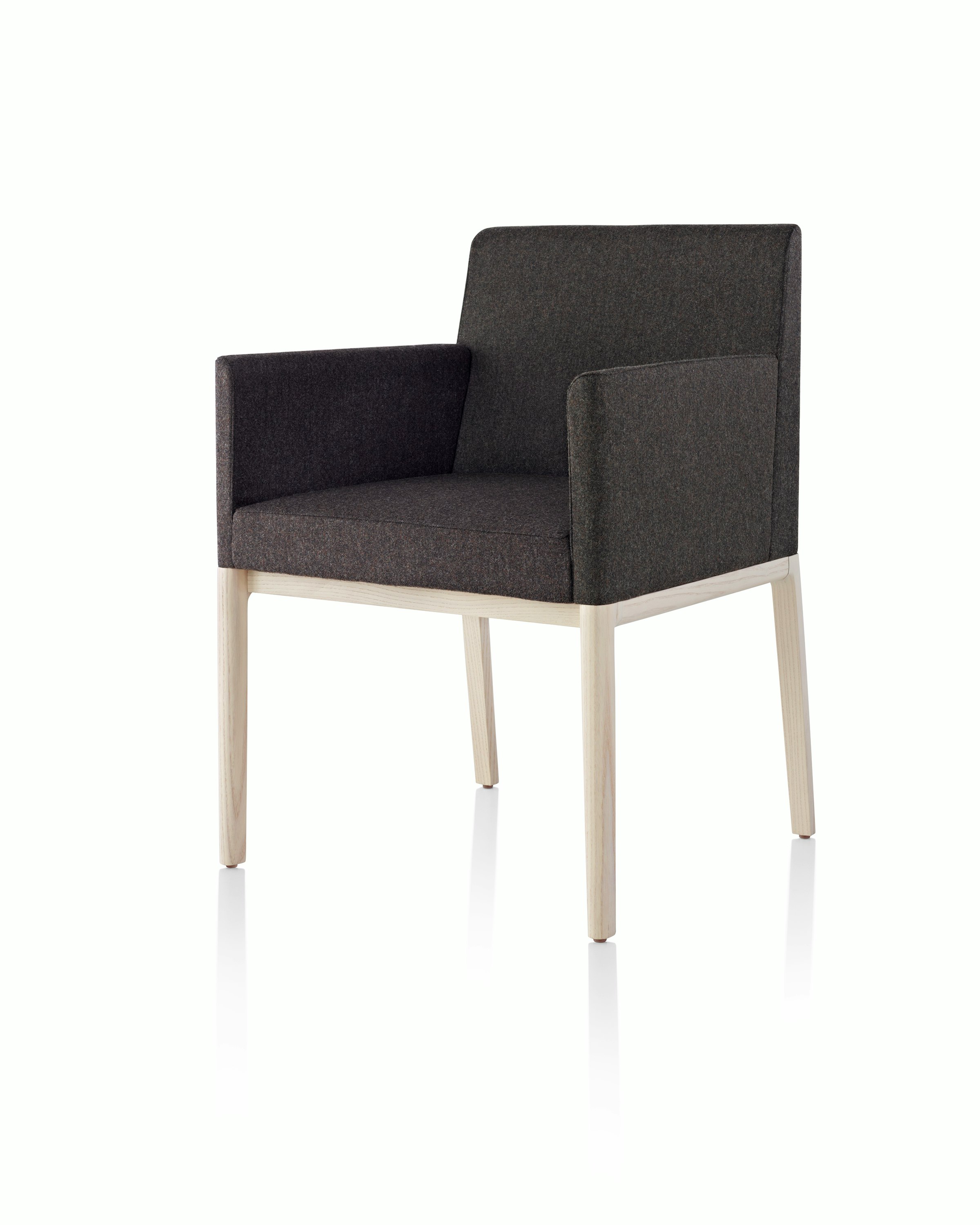 Angled view of a Nessel side chair with wraparound arms, showing the precision upholstery and wood craftsmanship.