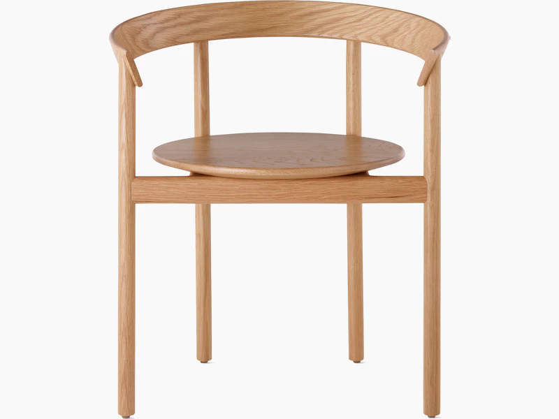 An oak Comma Chair with arms, viewed from the front.
