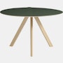 A front view of a round Copenhague Dining Table in oak with green top.