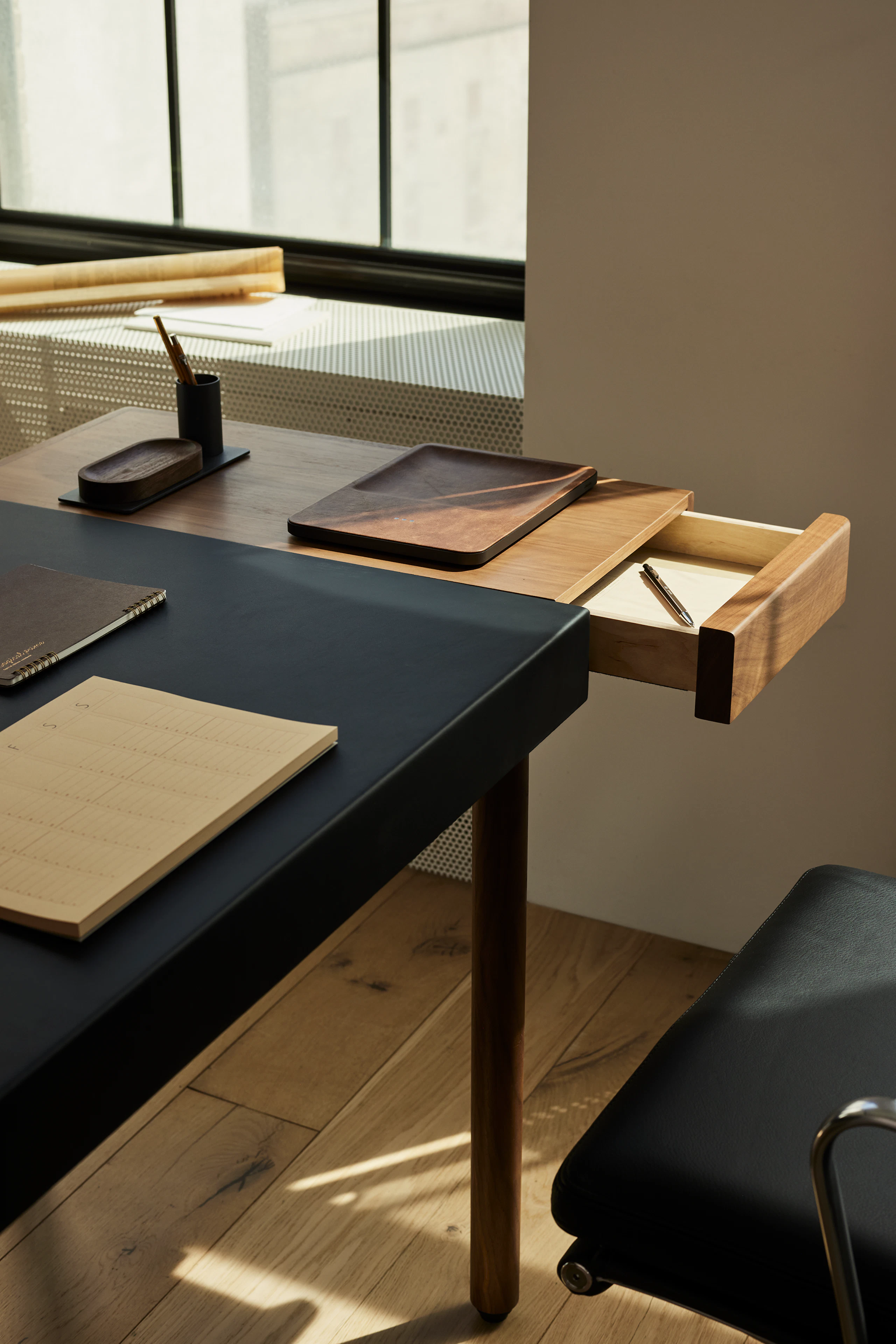 The New Canaan Leatherwrap Sit-to-Stand Desk in corporate office setting detail shot with open drawer.