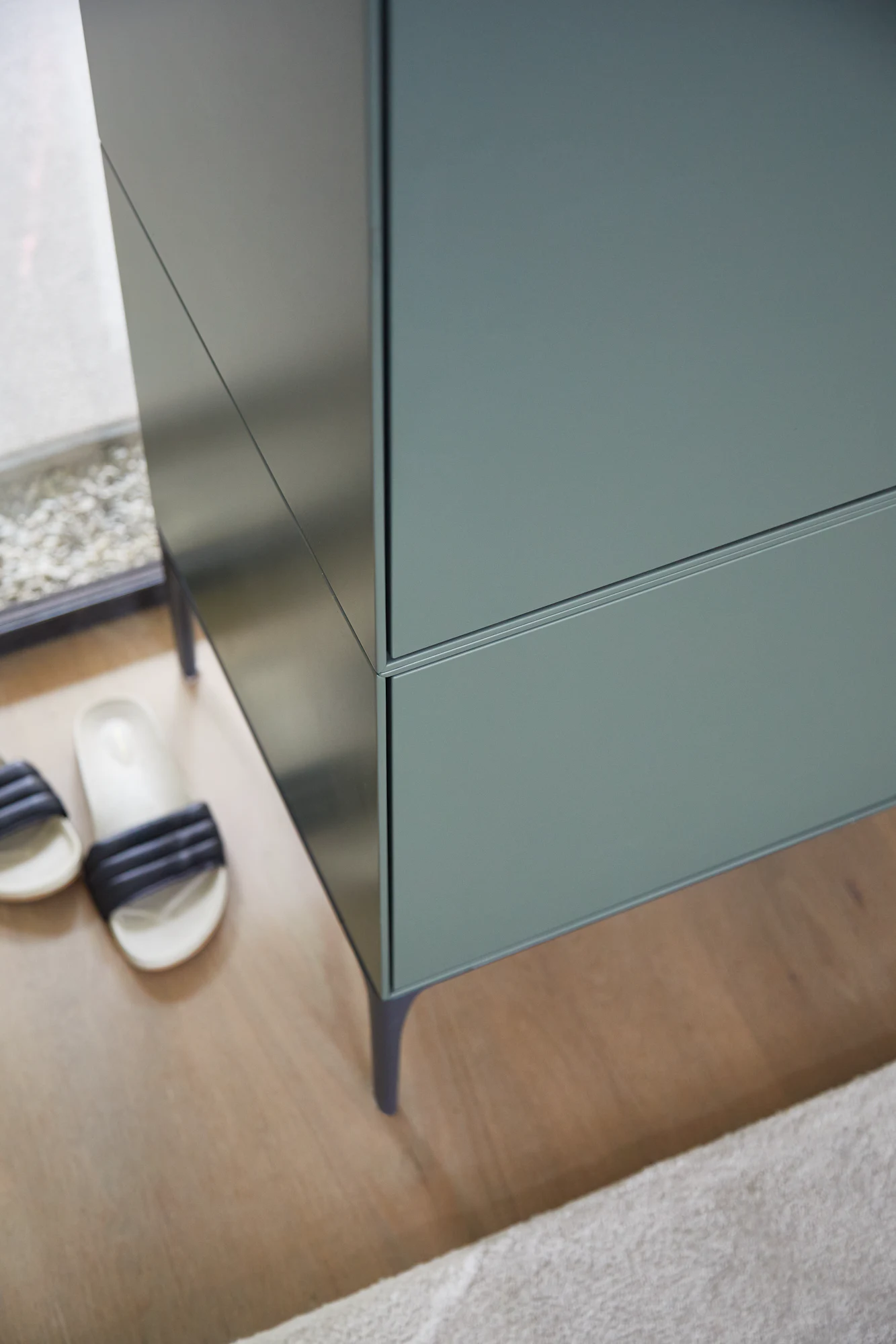 Side view of Lauki cabinet showing smooth panels and slim legs