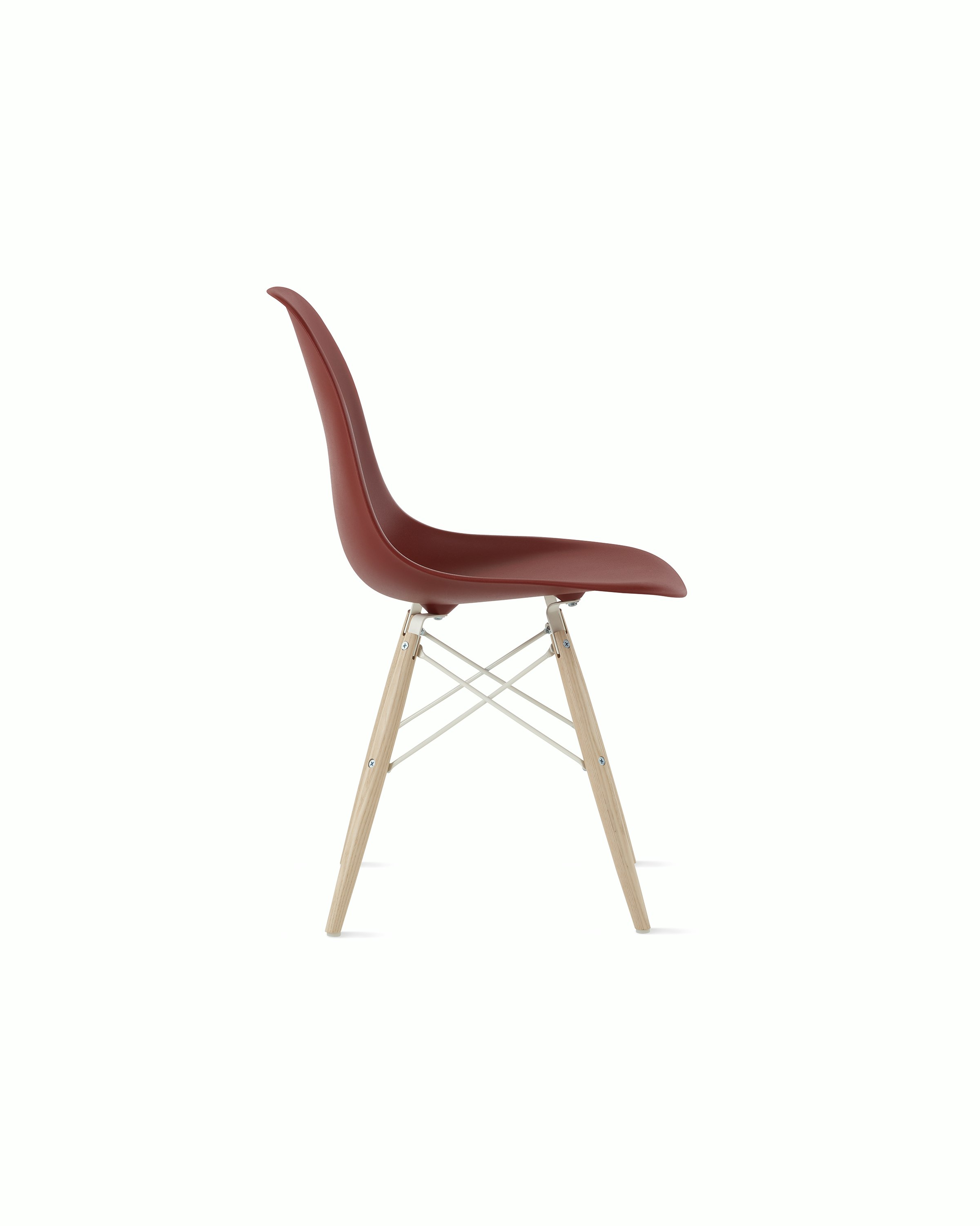 Side of brick red plastic shell chair with dowel base.