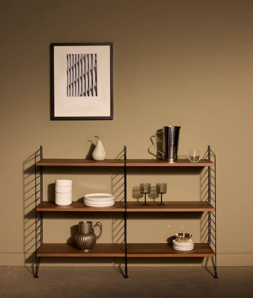 Shelving unit with various dishes on shelves in warm room