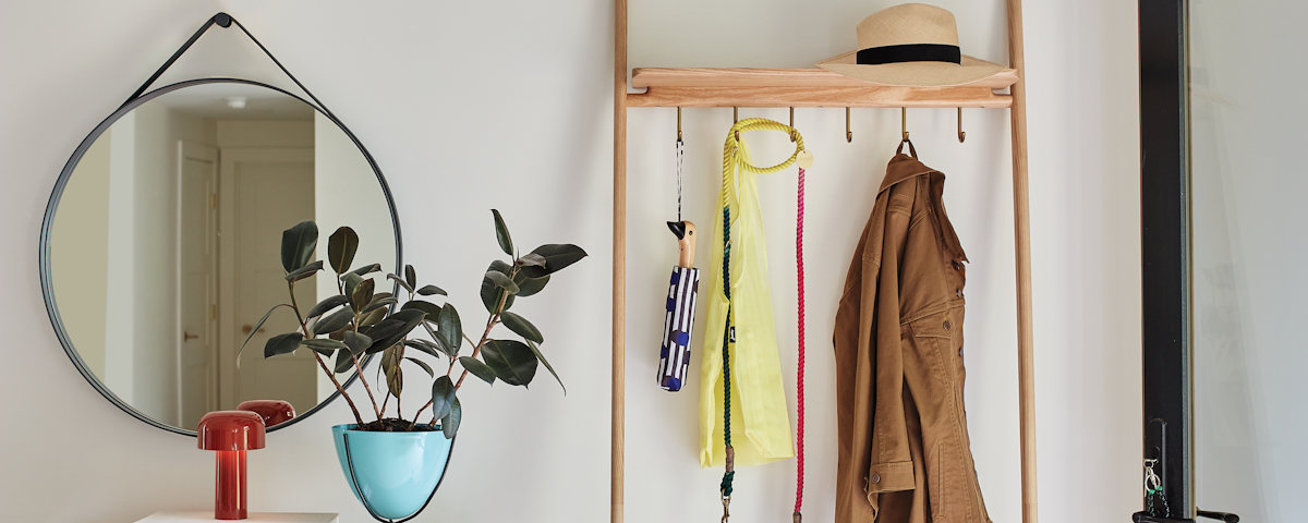 Folk Ladder Coatrack with coats and accessories in a home entryway