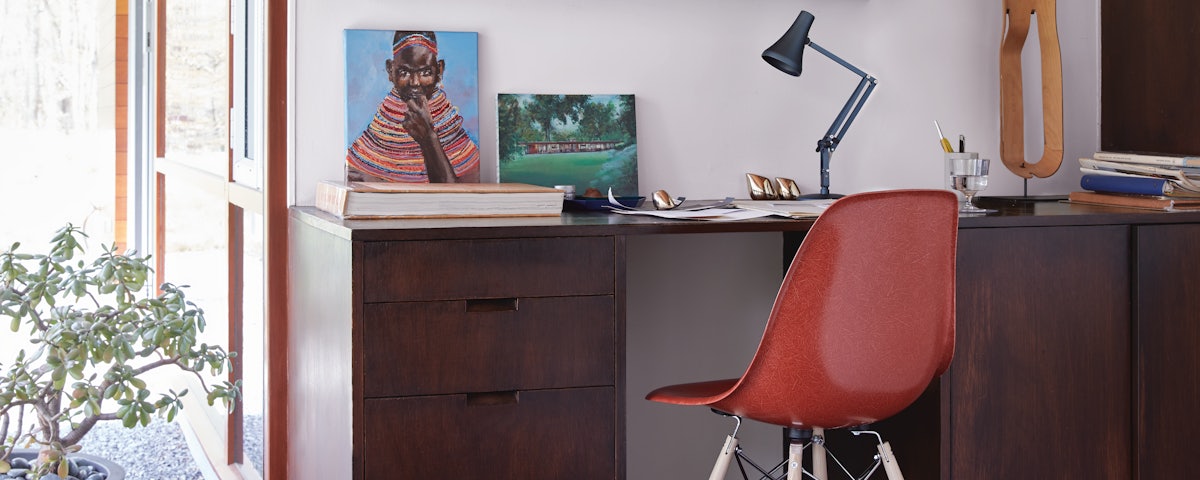 90 Mini Mini Desk Lamp and an Eames Molded Fiberglass Dowel Leg Side Chair at desk in a home office setting