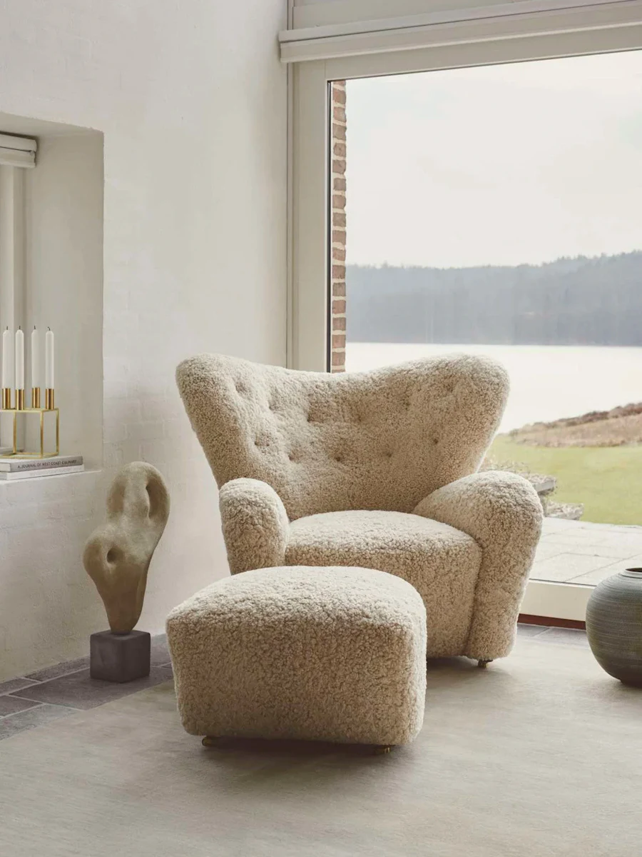 Close-up of cream boucle armchair showing rounded arms and tufted back with fluffy texture.