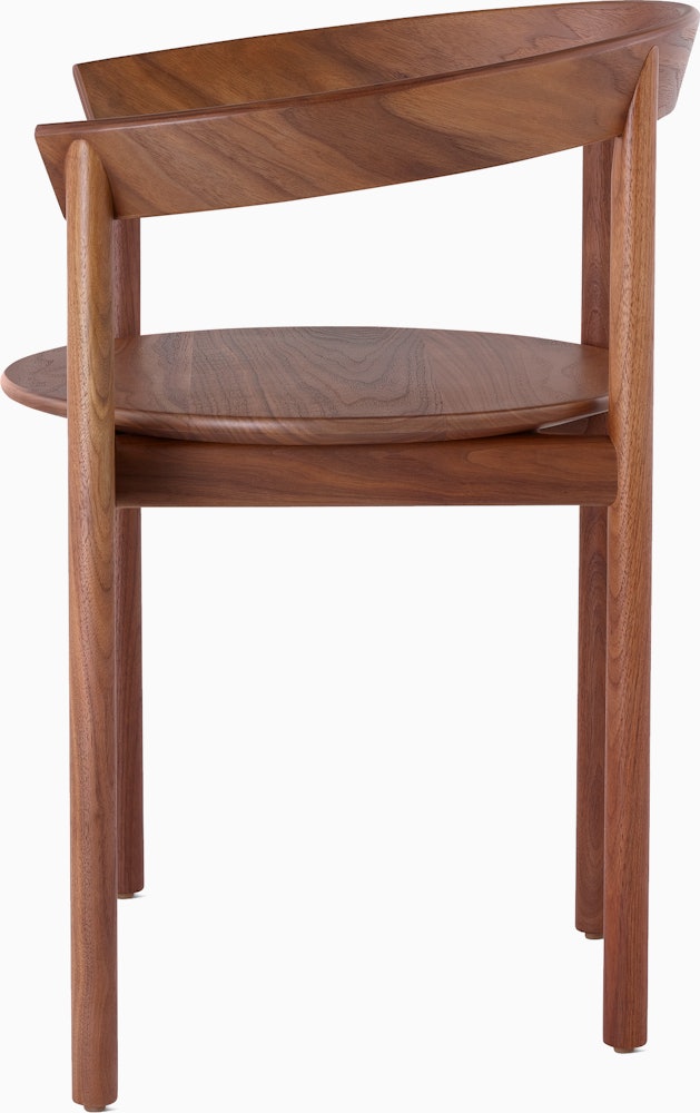 Profile view of a walnut Comma Chair with arms.