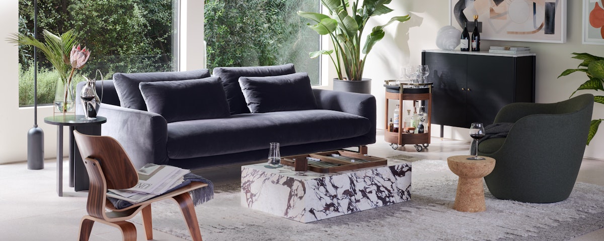 Lecco Sofa, Plinth Coffee Table, Lina Swivel and Eames Wooden Lounge Chair in a living room setting