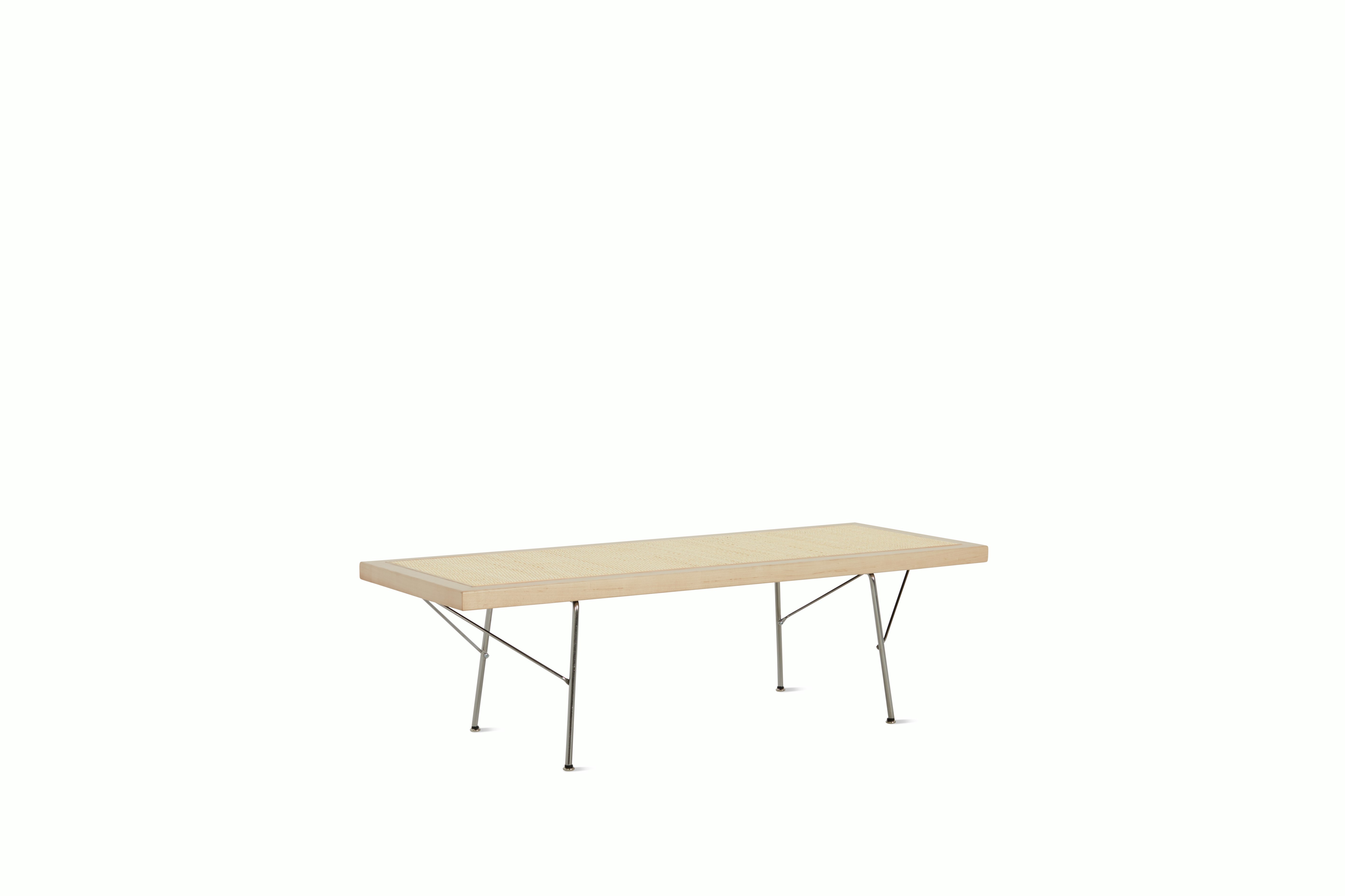 A Nelson Cane Bench with a walnut frame and metal legs, viewed at an angle.