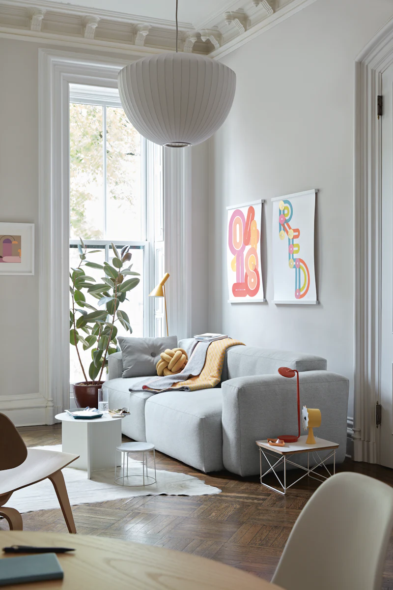Bright living room with blue sofa, orange chair, and yellow cabinet