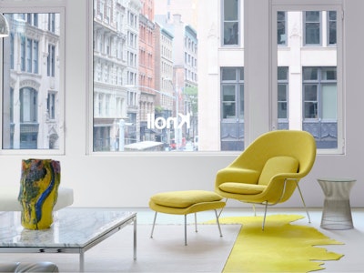 The Knoll showroom at 251 Park Avenue South in New York City featuring a marble coffee table, white sofa, and yellow Knoll Womb Chair and Ottoman