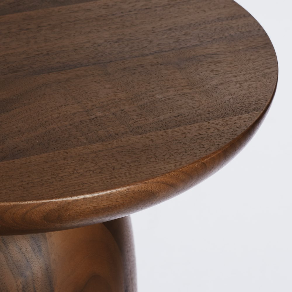 A close up view of the top surface of a Hew Side Table in a walnut finish.