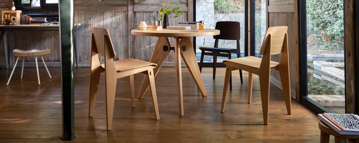 Chaise Tout Bois Chairs in Natural Oak surrounding a Prouvé Gueridon Table in a dining room setting