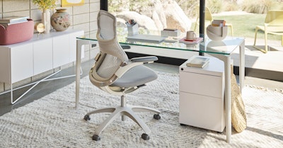 A home office featuring a Stromborg Table with a glass surface, and a Generation office chair.