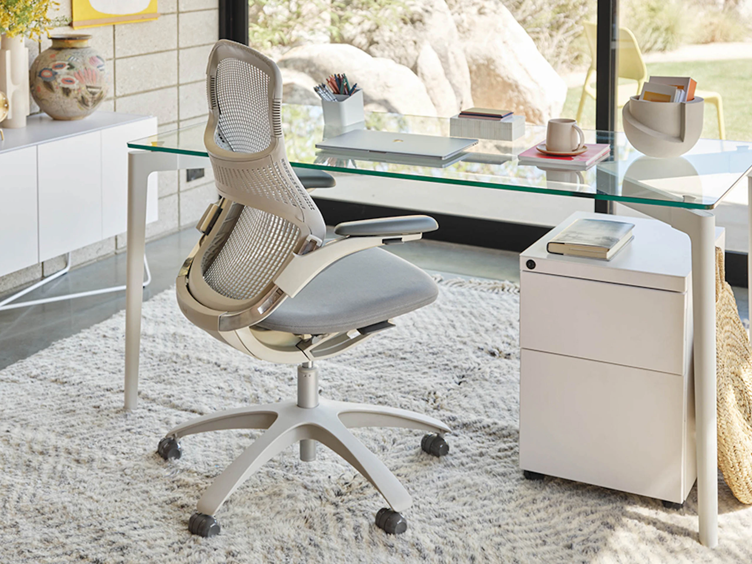 A home office featuring a Stromborg Table with a glass surface, and a Generation office chair.