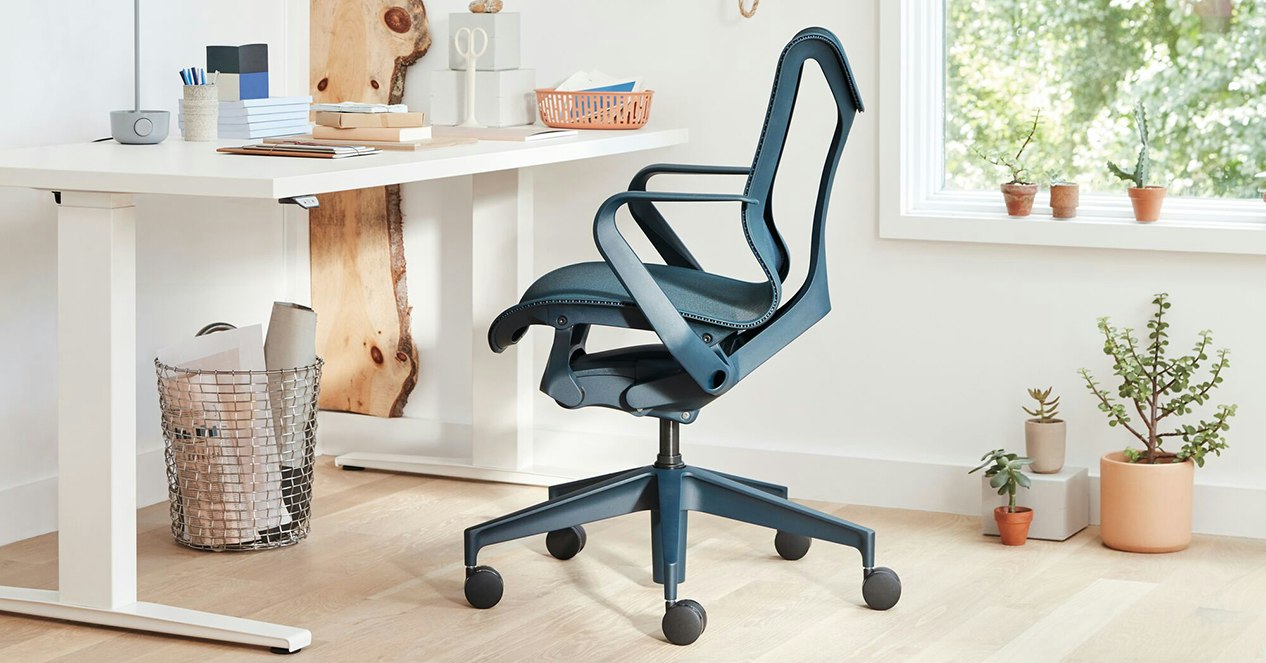 A blue Cosm office chair with a white Motia height-adjustable desk in a home office.