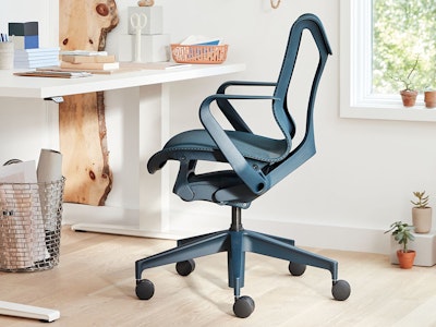 A blue Cosm office chair with a white Motia height-adjustable desk in a home office.