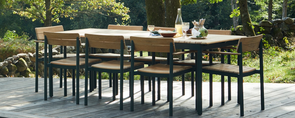 Pelagus Dining Table surrounded by Pelagus Dining Chairs in an outdoor patio setting