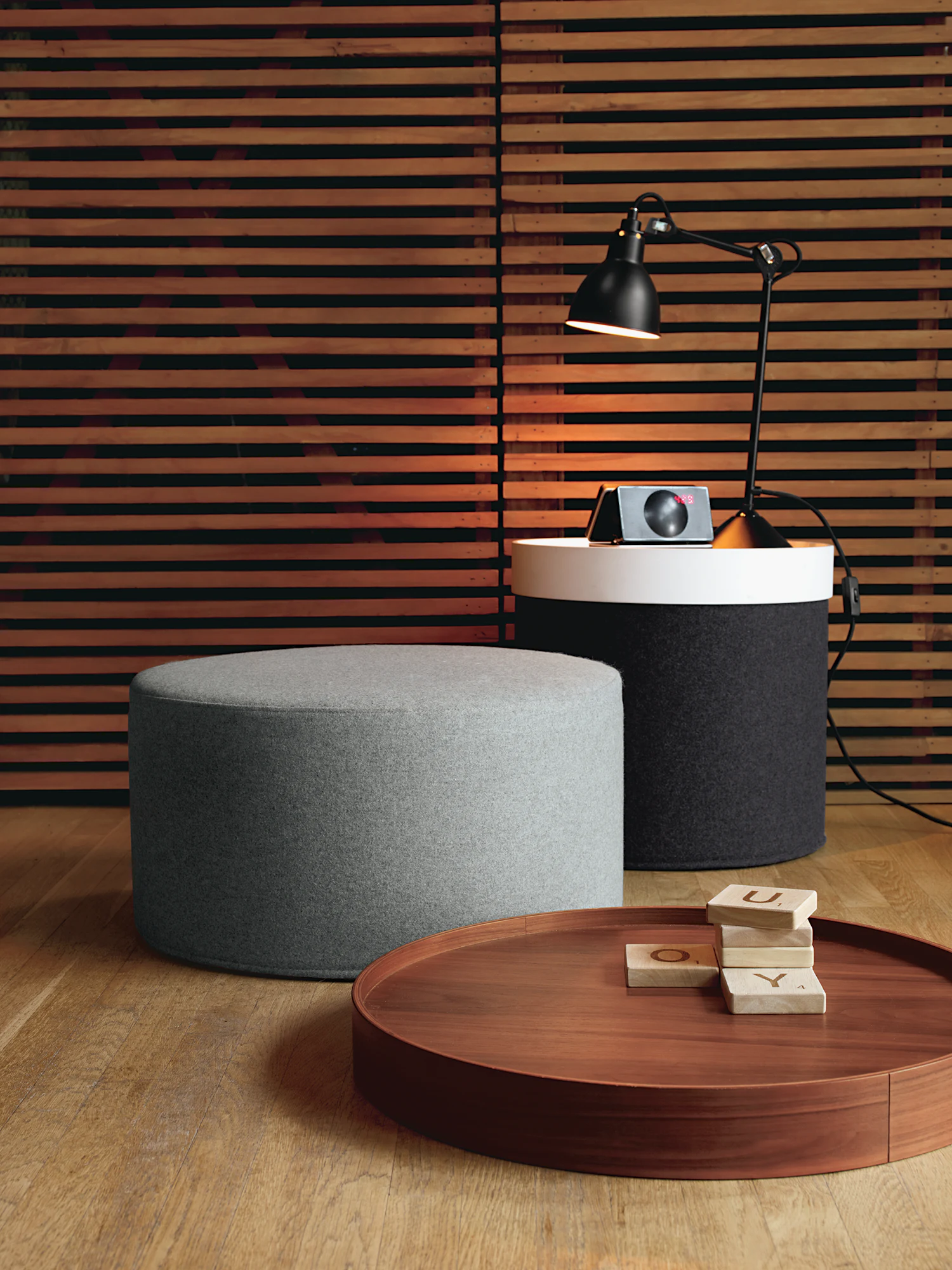 Grey wide drum pouf with rounded top and dense upholstered sides