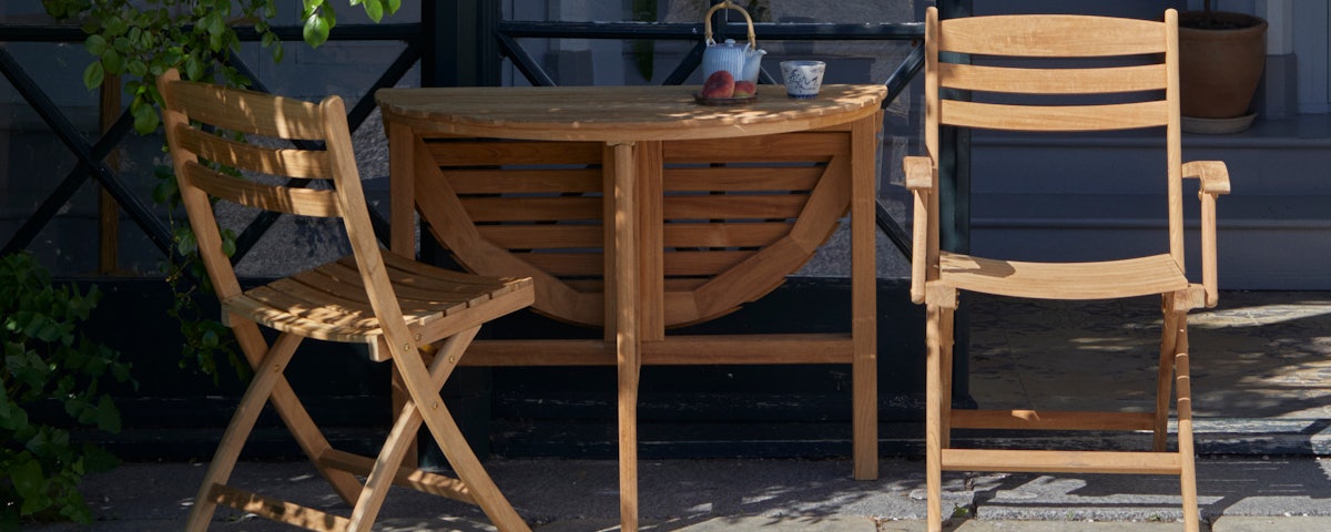 Selandia Gate-Leg Table surrounded by Selandia Chairs in an outdoor patio setting