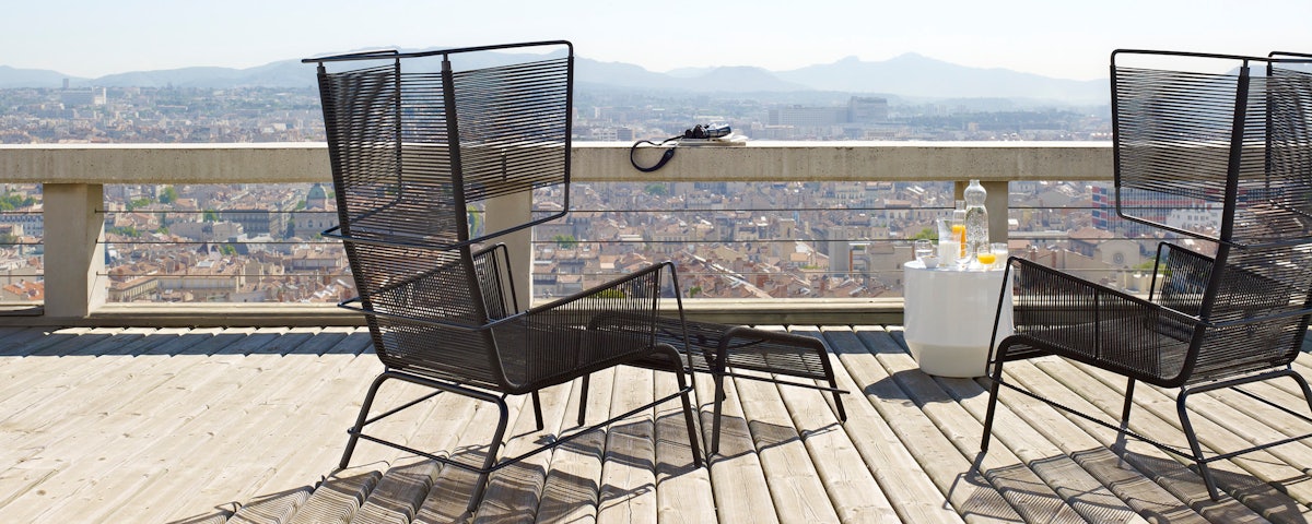 Two Fifty Lounge Chairs on a wood deck overlooking a cityscape