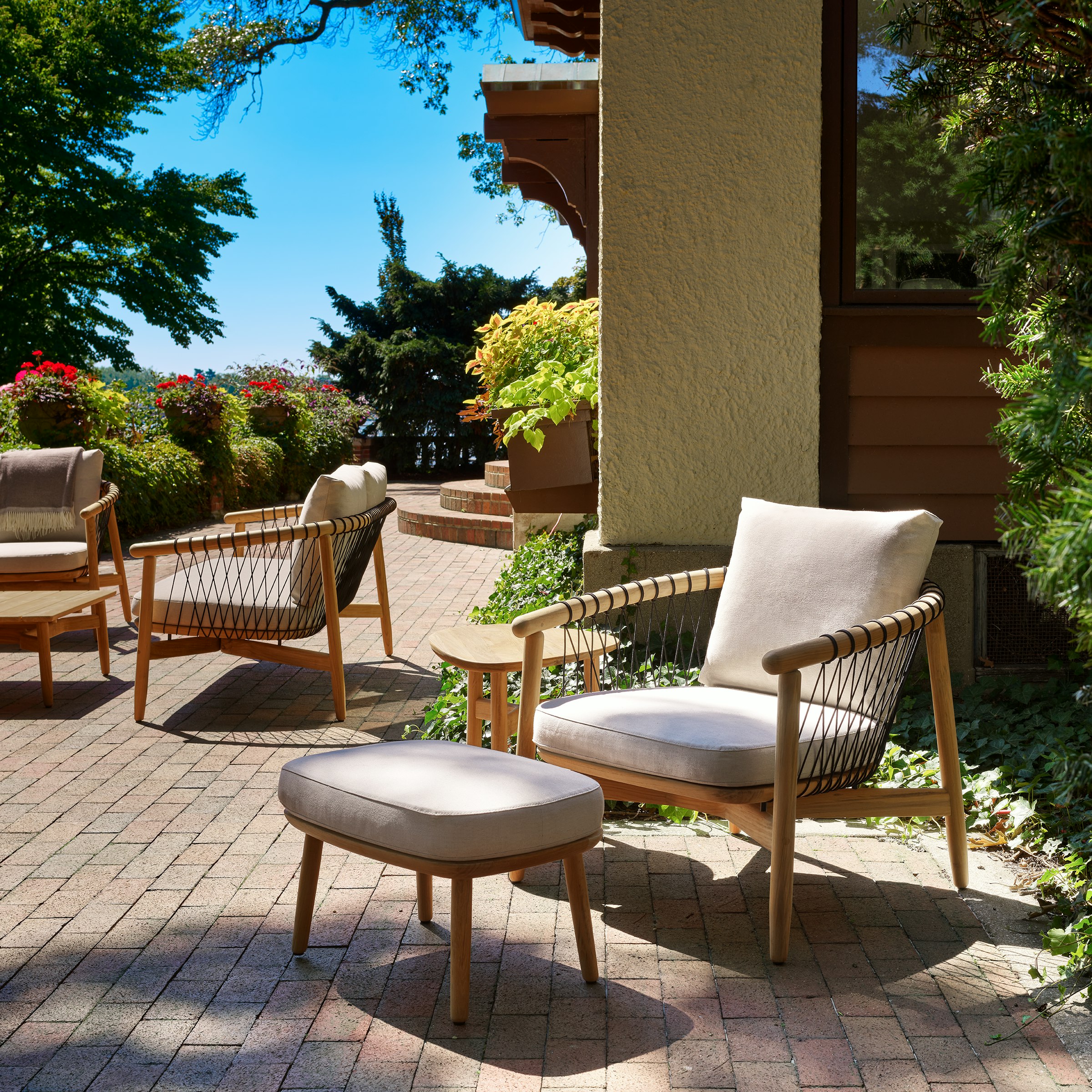 Crosshatch Outdoor Lounge Chair and Ottoman with Trilobe Side Table in an environmental setting.