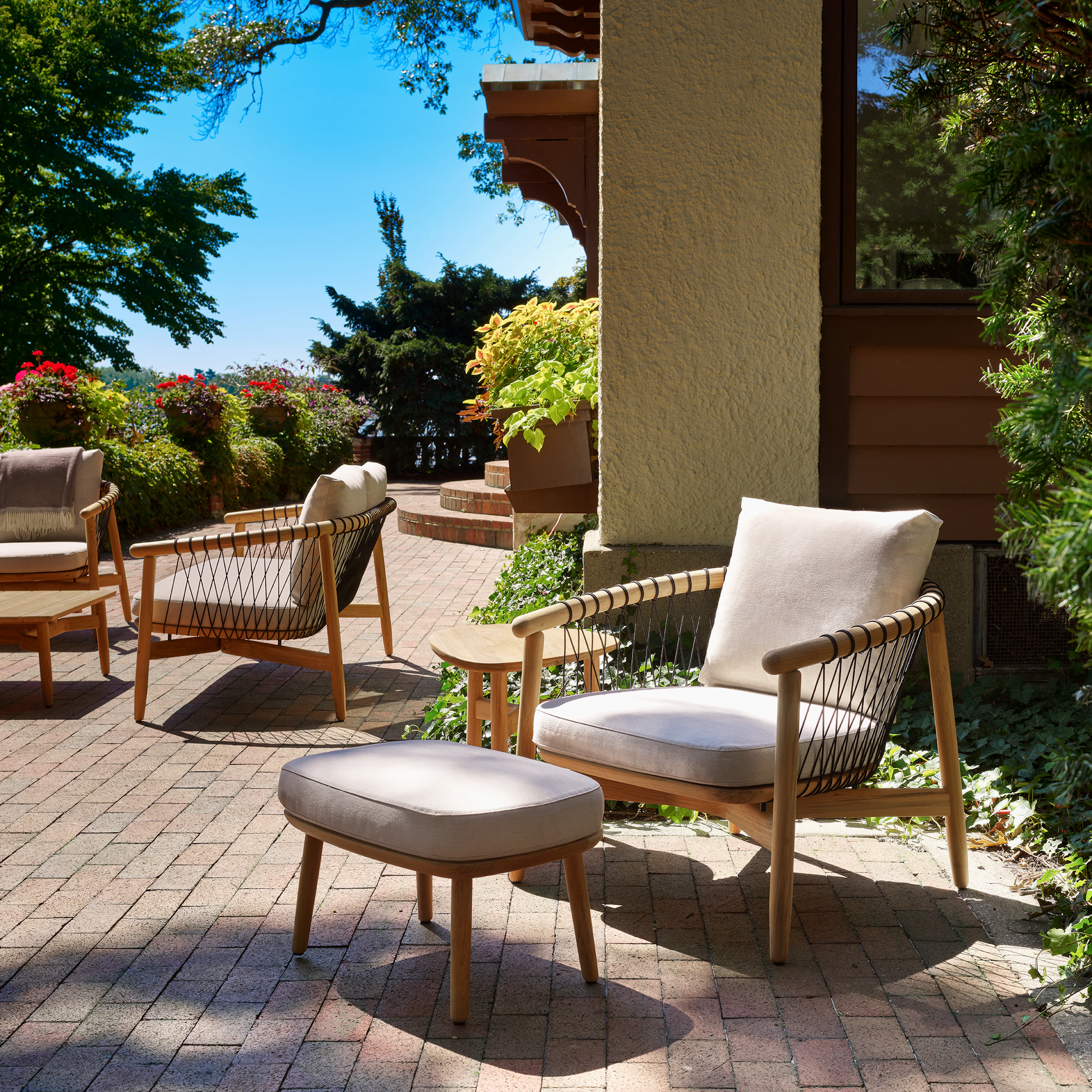 Crosshatch Outdoor Lounge Chair and Ottoman with Trilobe Side Table in an environmental setting.