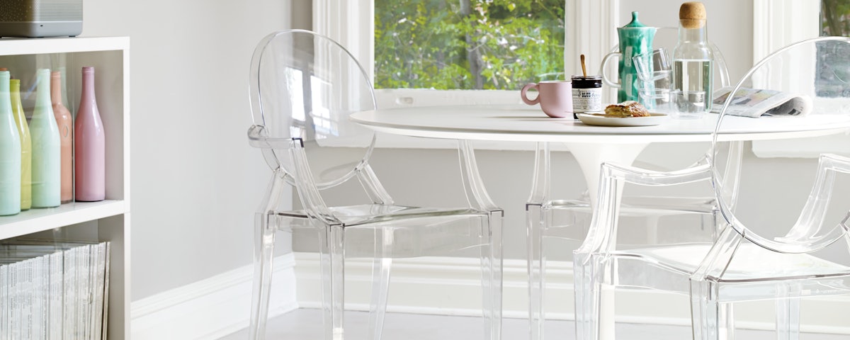 Two Louis Ghost Chairs at a Saarinen Dining Table with breakfast items