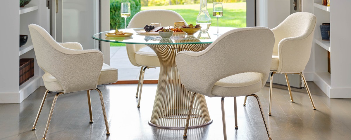Platner Dining Table surrounded by six Bertoia Dining Chairs in a dining room setting