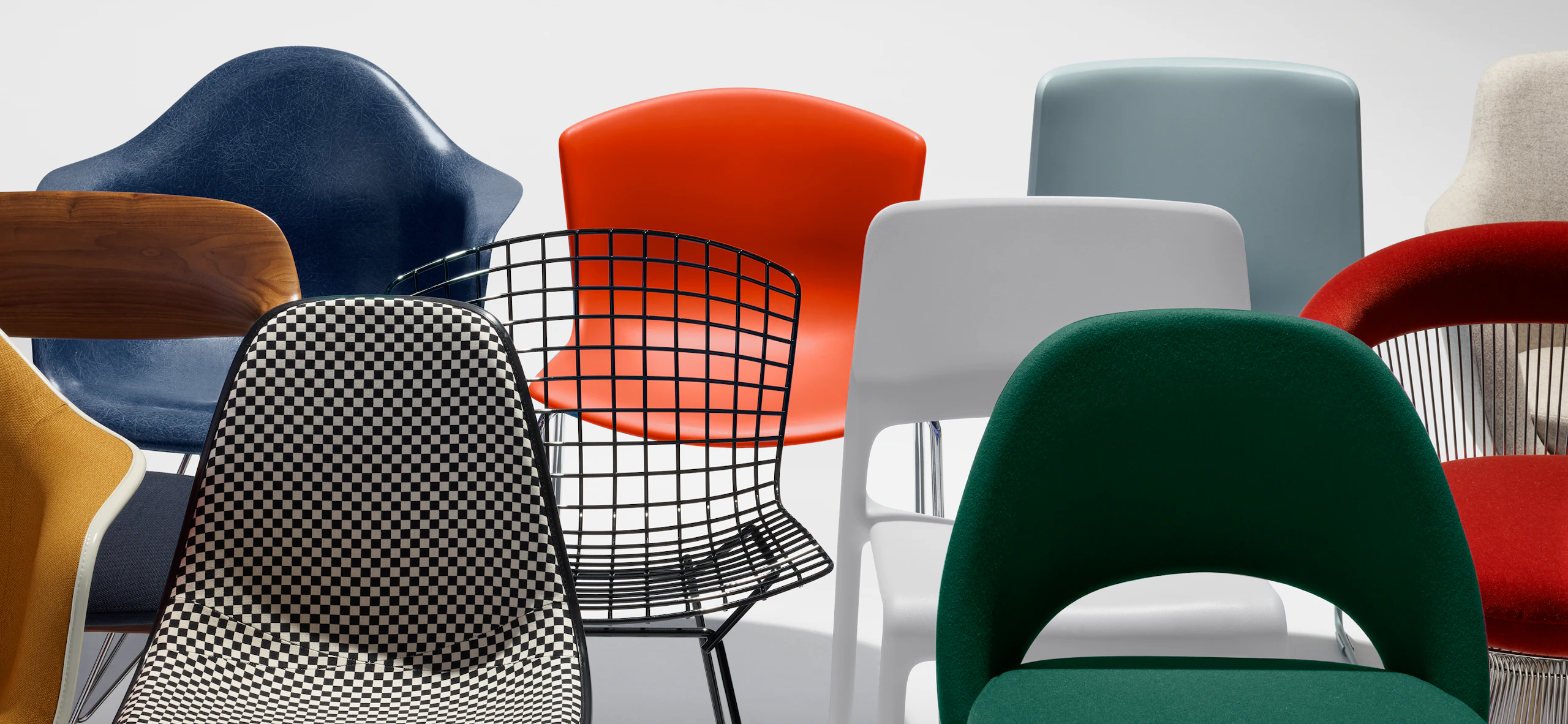 A collection of colourful chairs from the MillerKnoll collective including Eames Shell Chairs and a Saarinen Executive Chair. 