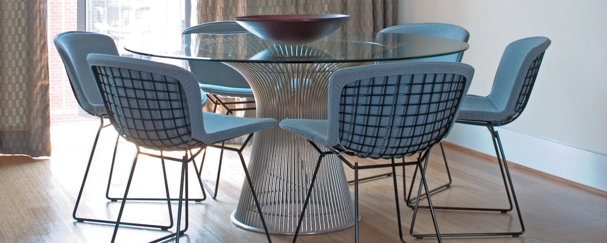 Platner Dining Table surrounded by six Bertoia Dining Chairs in a dining room setting