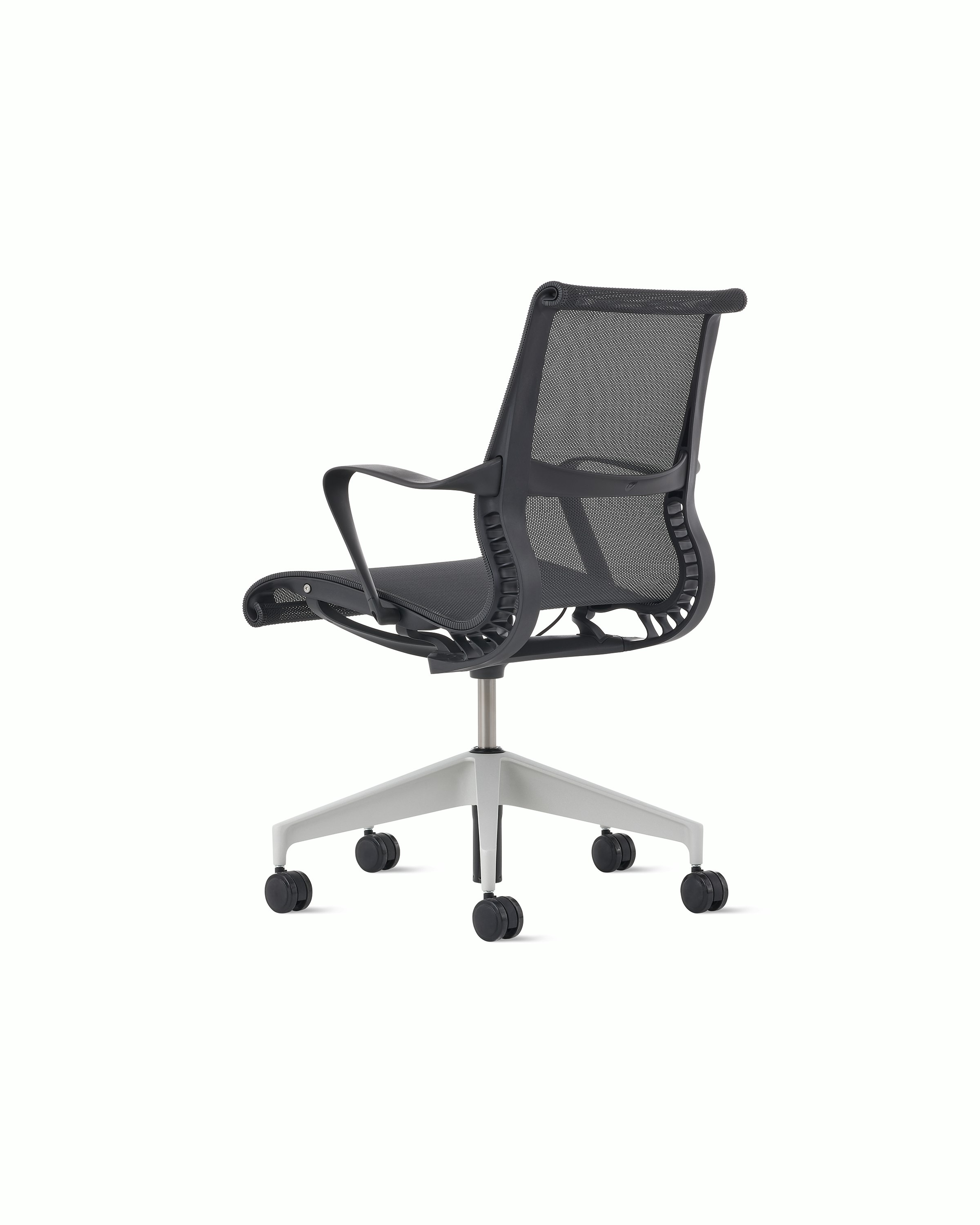 Rear angle view of a Setu chair in dark grey with a silver alloy base.