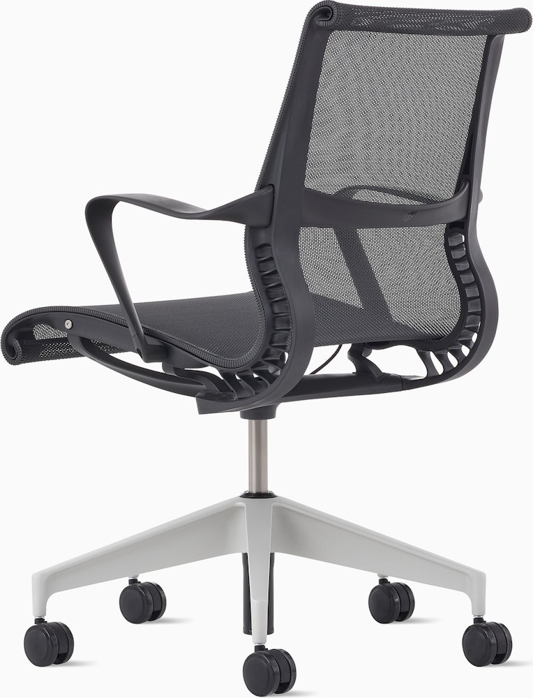 Rear angle view of a Setu chair in dark grey with a silver alloy base.