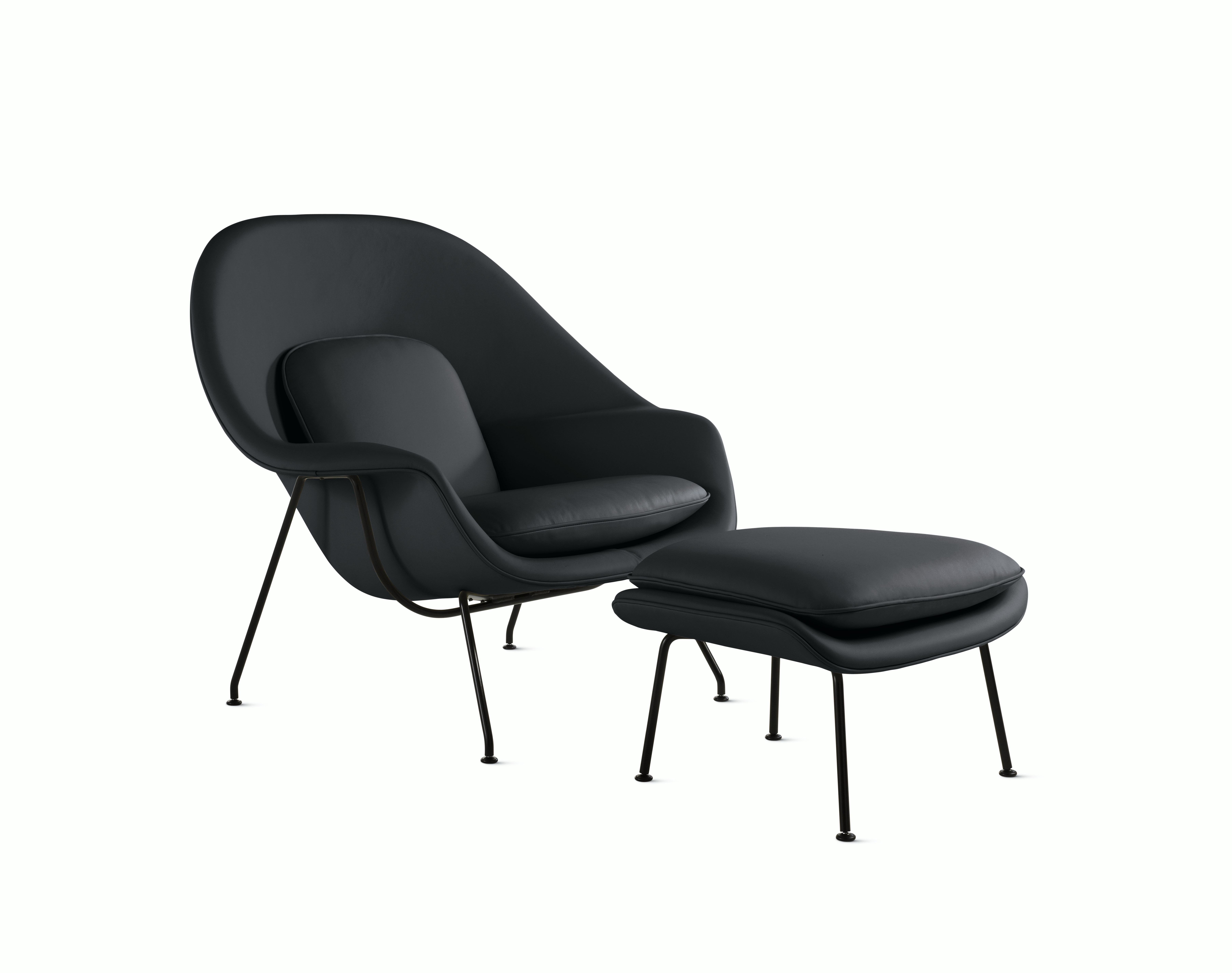 A black Womb Chair & Ottoman viewed from an angle