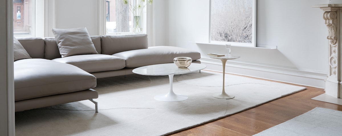 Como Open Sectional, Saarinen Coffee and Side Tables and Onda Rug in a living room setting