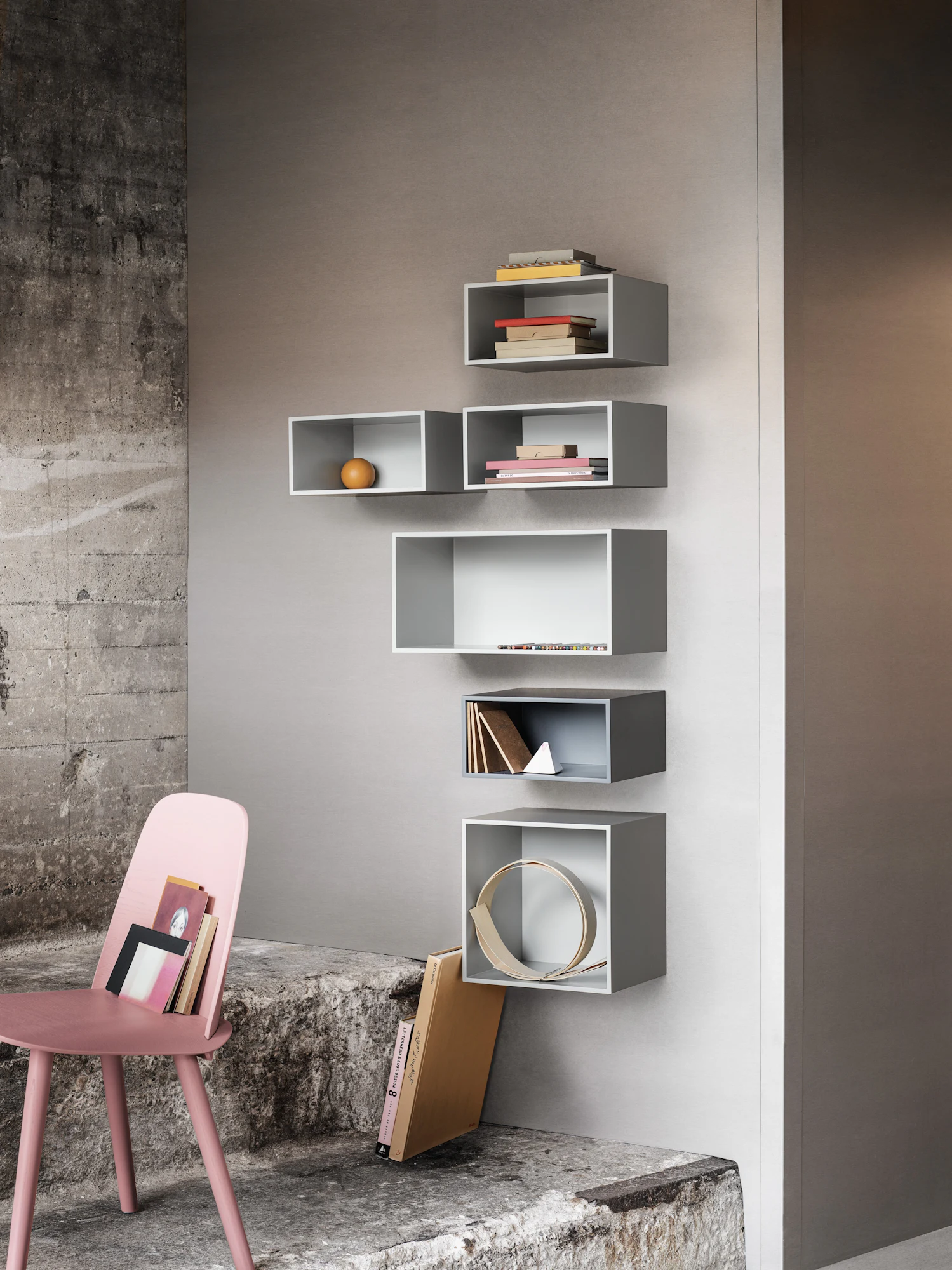 Nerd Chair in light pink upholstery next to wall shelving.