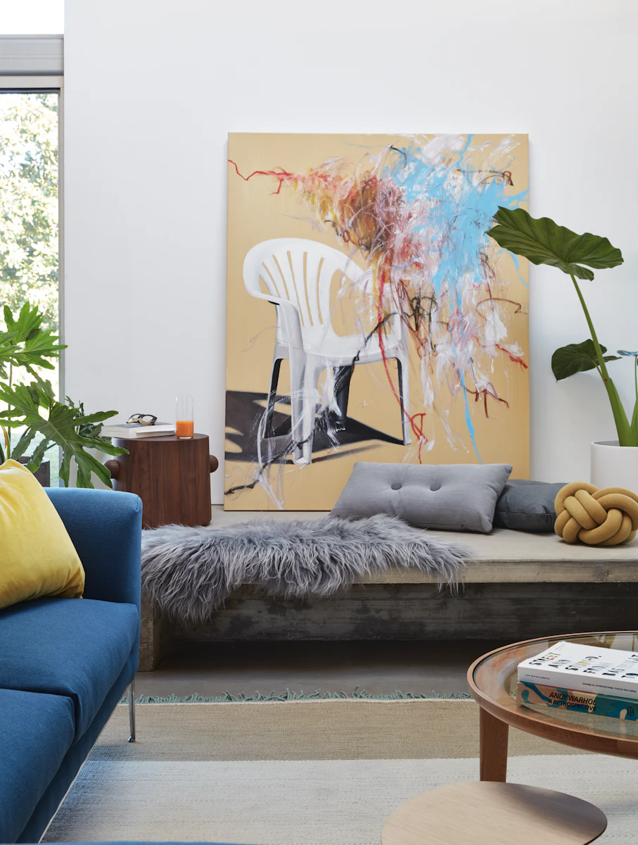 White chair and colorful abstract painting in a modern living room